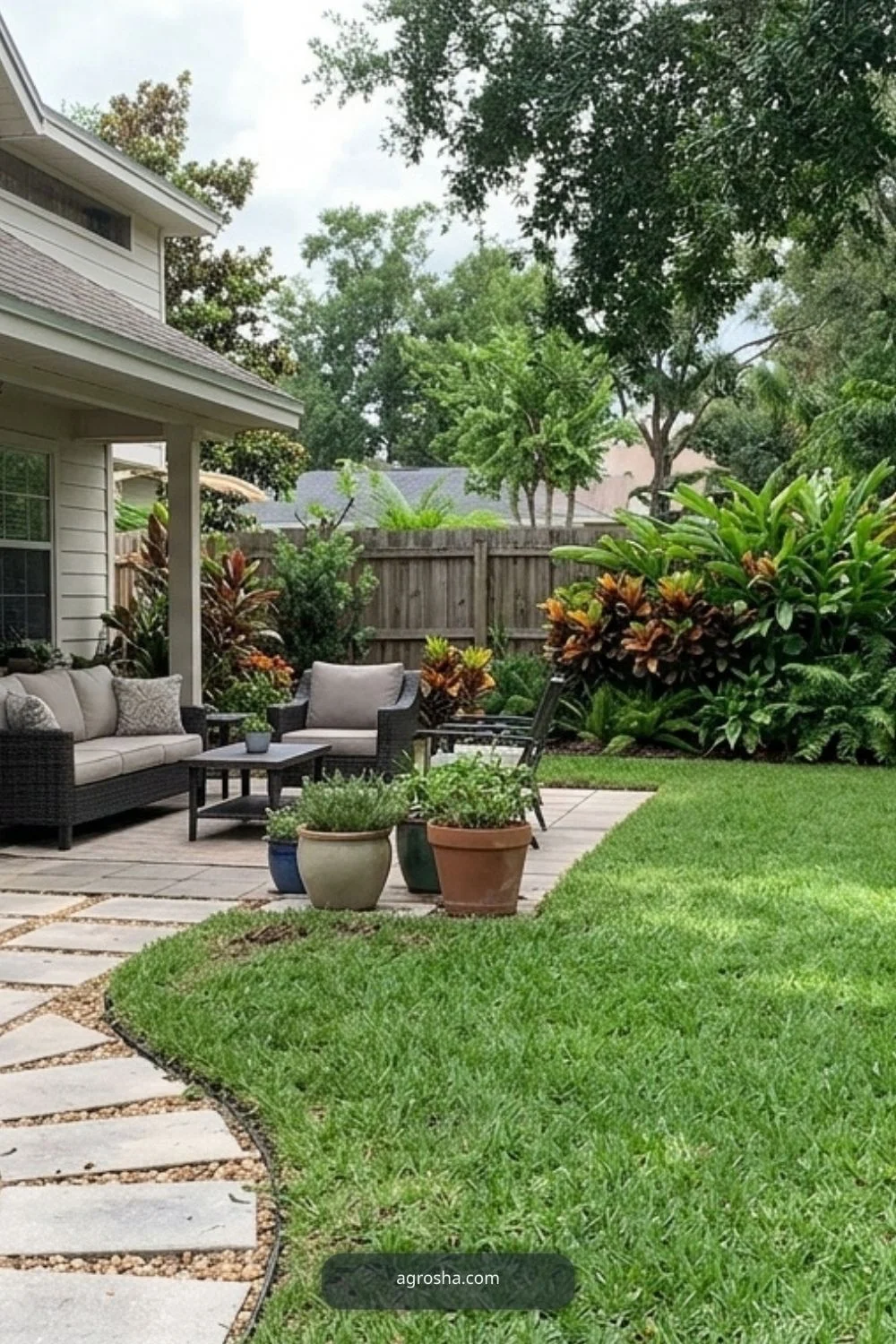 Practical Florida backyard with phased upgrades including patio, path, planting, privacy, and open lawn