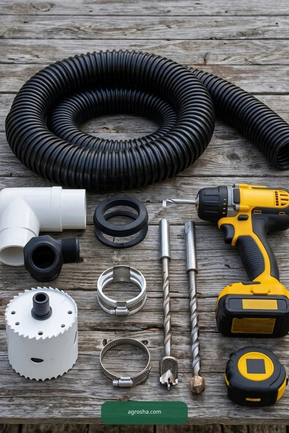 Corrugated overflow hose, PVC fittings, drill, hose clamps and mesh screen prepared for rain barrel work