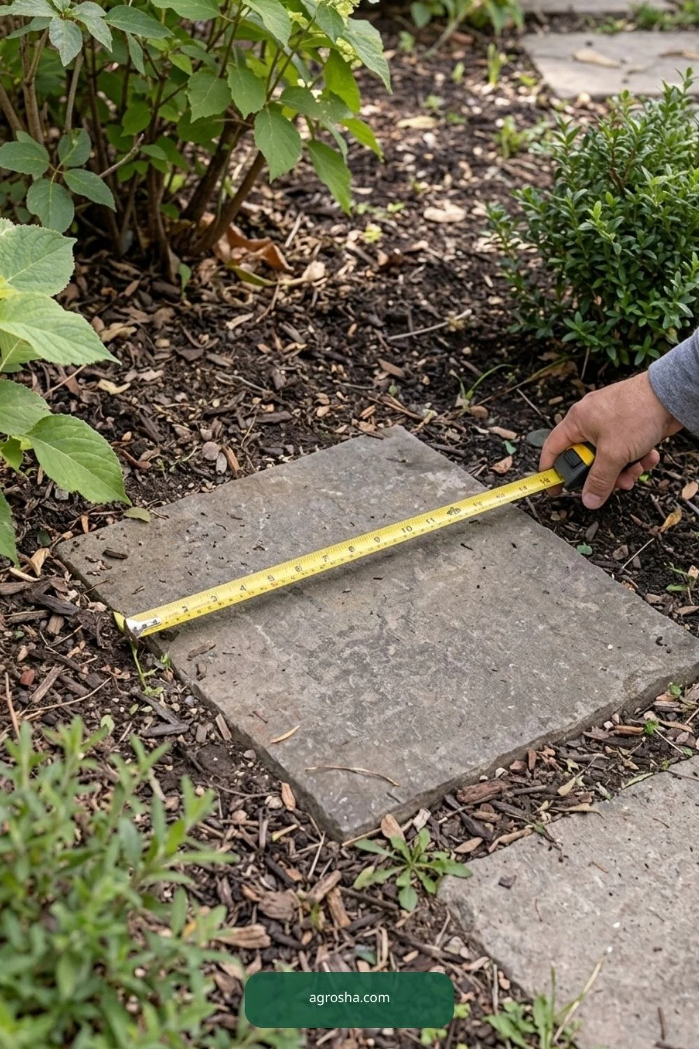 Hands measuring the width of a flat stone base for a terracotta bird bath
