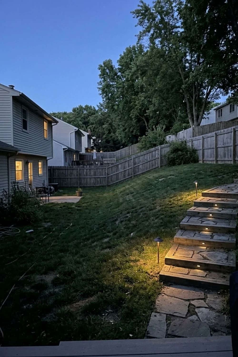 Integrated Landscape Lighting integrated into a sloped suburban backyard